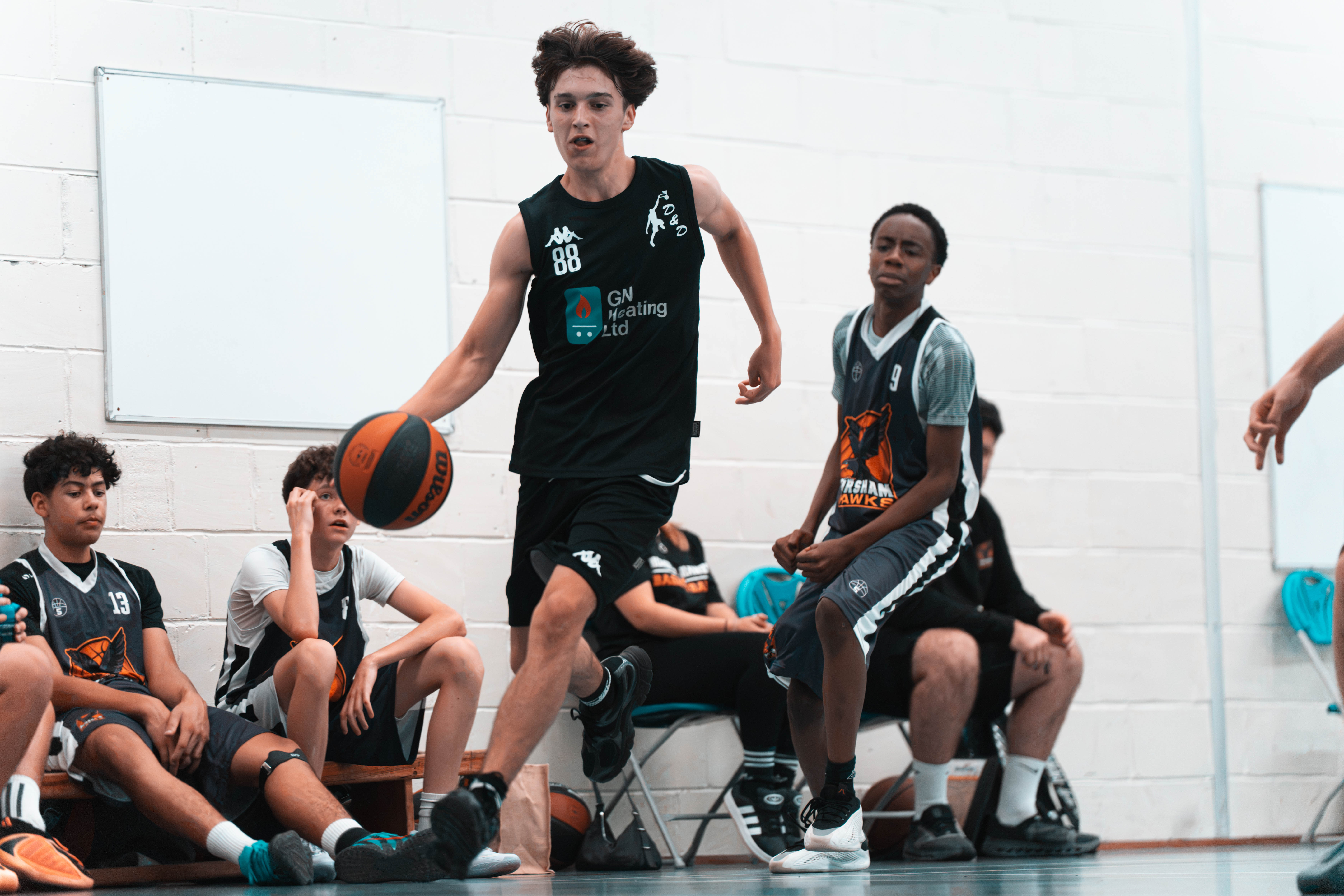 A Worthing D&D U16 Hustlers player in a black kit driving toward the basket